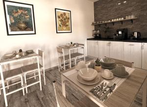 a kitchen with a table with dishes on it at Kalasó Design Guest House - Rome Airport in Fiumicino