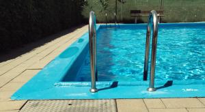 a blue swimming pool with two metal bars in it at S'Mitterer in Itter