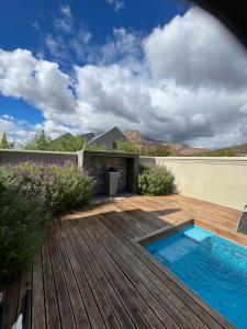a backyard with a wooden deck and a swimming pool at Sage in Montagu
