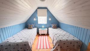 two beds in a room with blue walls at Puhkemaja saunaga Villa Hanson in Noarootsi