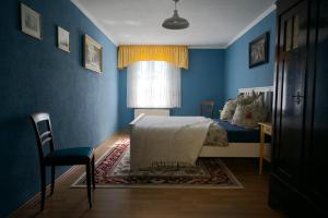 a blue bedroom with a bed and a window at auf der Muehle zwei in Zerbst