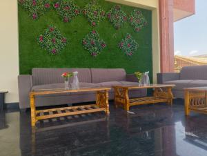 a living room with two tables and a couch at Hotel Golchi Palace in Lālsot