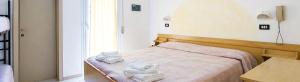 a bedroom with a bed with towels on it at Hotel Maria Luisa in Rimini