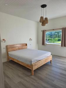 a bedroom with a bed in a room with a window at Kanchana home stay กาญจนา โฮมสเตย์ สุราษฏร์ in Ban Bo Thong