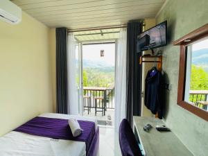 a hotel room with a bed and a window with a view at Almost Heaven in Talawakele