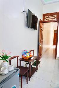 a dining room with a table and a television on a wall at Nhà nghỉ Việt Mến in Sầm Sơn