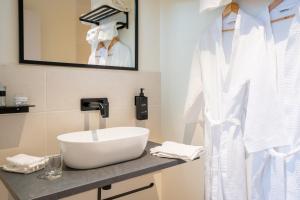 a bathroom with a white sink and a mirror at L'Hostellerie de La Licorne in Fontevraud-l'Abbaye