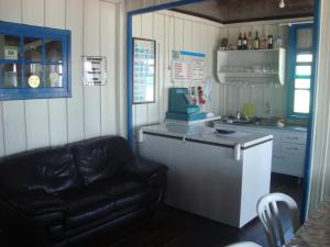 a kitchen with a black leather couch and a counter at Dona Quinota in Ilha do Mel