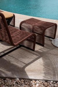 two wicker chairs and a table next to a pool at Good Days Habitat Soma Bay in Hurghada