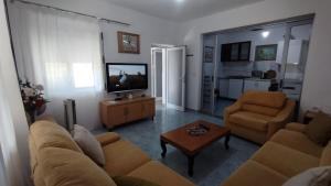a living room with a couch and two chairs and a television at Lili's House in Delvinë