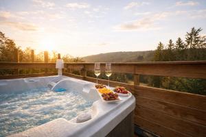 a hot tub with a bowl of fruit and wine glasses at Le lofty in Stoumont +27 photos