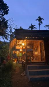 a wooden house with lights on the outside of it at Tetebatu Cabin Hut in Tetebatu