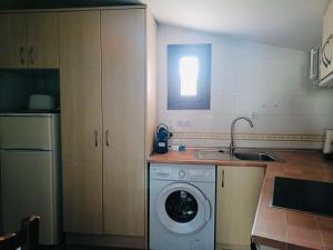 a kitchen with a washing machine and a window at Parada del Carmen in Albarracín