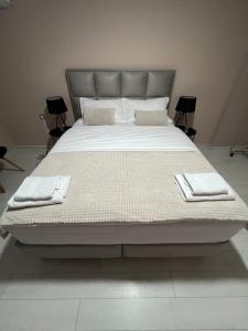 a large bed with white sheets and towels on it at Apartmani Gala Foča in Foča