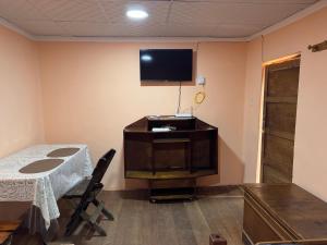 a room with a table and a television on the wall at Casa Oruro Valvic in Oruro