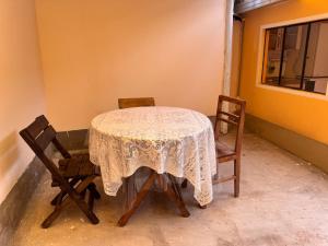 a table with two chairs and a table with a lace table cloth at Casa Oruro Valvic in Oruro