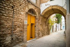 an alley with a yellow door on a building at Dar El Rezk in Tunis +10 photos