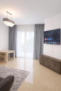 a living room with a couch and a tv on the wall at Lapta SEL in Ayios Dhometios