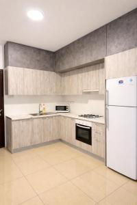 a kitchen with a white refrigerator and cabinets at Lapta SEL in Ayios Dhometios