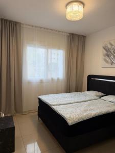 a bedroom with a bed and a window and a chandelier at Lapta SEL in Ayios Dhometios