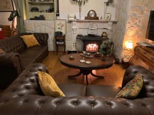 a living room with a couch and a table with a fireplace at B&B Petit Chateau - Rust en Charme Nabij Gent, Brugge en de Zeeuwse kust in Biervliet
