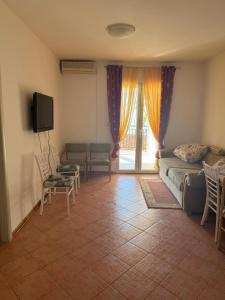 a living room with a couch and chairs and a tv at Villa Palma in Prijevor