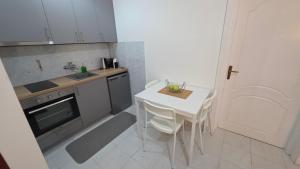 a small kitchen with a white table and a sink at Apartments 101 in Kotor