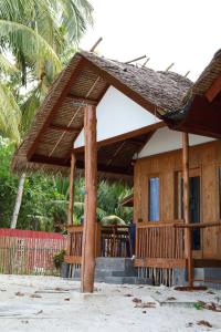 a wooden house with a thatched roof at Buggei Surfcamp Mentawai in Katiet +17 photos