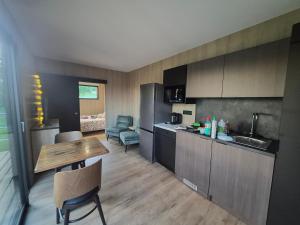 a kitchen with a table and a kitchen with a dining room at TREE LODGY - LE CHARME - Nouveau espace bien être disponible in Ray-sur-Saône +18 photos