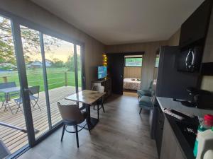 a living room with a table and a balcony at TREE LODGY - LE CHARME - Nouveau espace bien être disponible in Ray-sur-Saône