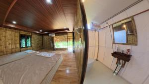 a bedroom with a bed and a toilet in a room at Pu Luong Roots Homestay in Pu Luong