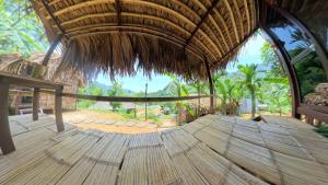 a room with a wooden floor and a straw roof at Pu Luong Roots Homestay in Pu Luong +14 photos
