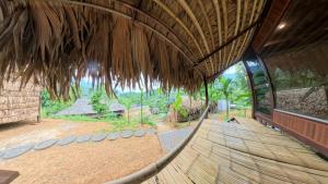 a view from the inside of a building with a thatched roof at Pu Luong Roots Homestay in Pu Luong