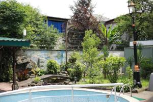 a swimming pool in a yard with a garden at Green House Hotel N2 in Kobuleti