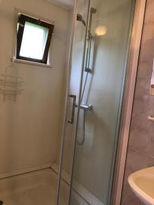 a shower in a bathroom with a sink at De Merel in Pieterburen
