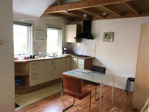 a kitchen with a table and a counter top at De Merel in Pieterburen