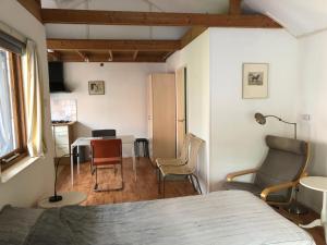 a bedroom with a bed and chairs and a table at De Merel in Pieterburen