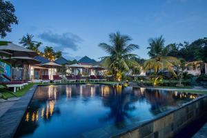 a swimming pool in a resort at night at Secret Point Huts in Nusa Lembongan