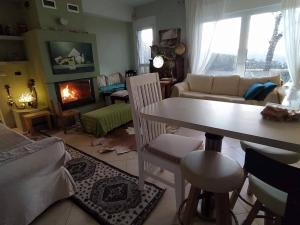a living room with a table and a fireplace at To Fournaraki in Gialiskari