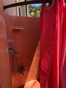 a bathroom with a red shower curtain and a tub at To Fournaraki in Gialiskari +30 photos