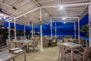 a restaurant with tables and chairs on a deck at Secret Point Huts in Nusa Lembongan
