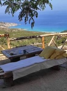 a bed on a table with a view of the ocean at To Fournaraki in Gialiskari