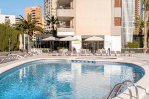 a swimming pool with chairs and tables and umbrellas at Primavera Loix in Benidorm +15 photos