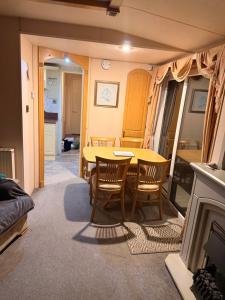 a dining room with a yellow table and chairs at Sea View Static Caravan With Decking - Skipsea Sands Holiday Park in Skipsea
