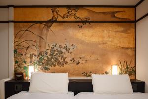 two beds in a bedroom with a painting on the wall at OYASUMI Art HOTEL Dotonbori 24-Hour Check-in Pressure-relief mattress in Osaka
