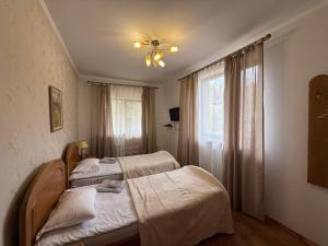 two beds in a room with a window at Guest House Danver in Yaremche +50 photos