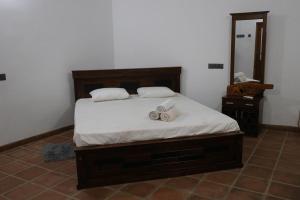 a bedroom with a bed with two slippers on it at Ceylon Luminara in Veyangoda