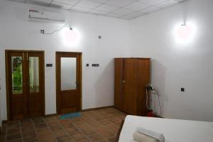 a room with two wooden doors and a room with at Ceylon Luminara in Veyangoda