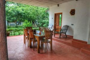 a wooden table and chairs on a patio at Ceylon Luminara in Veyangoda