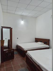 a room with two beds and a mirror in it at Ceylon Luminara in Veyangoda